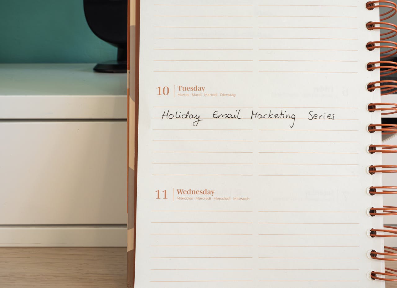 Planner open on a desk with handwritten Holiday Email Marketing Series note.
